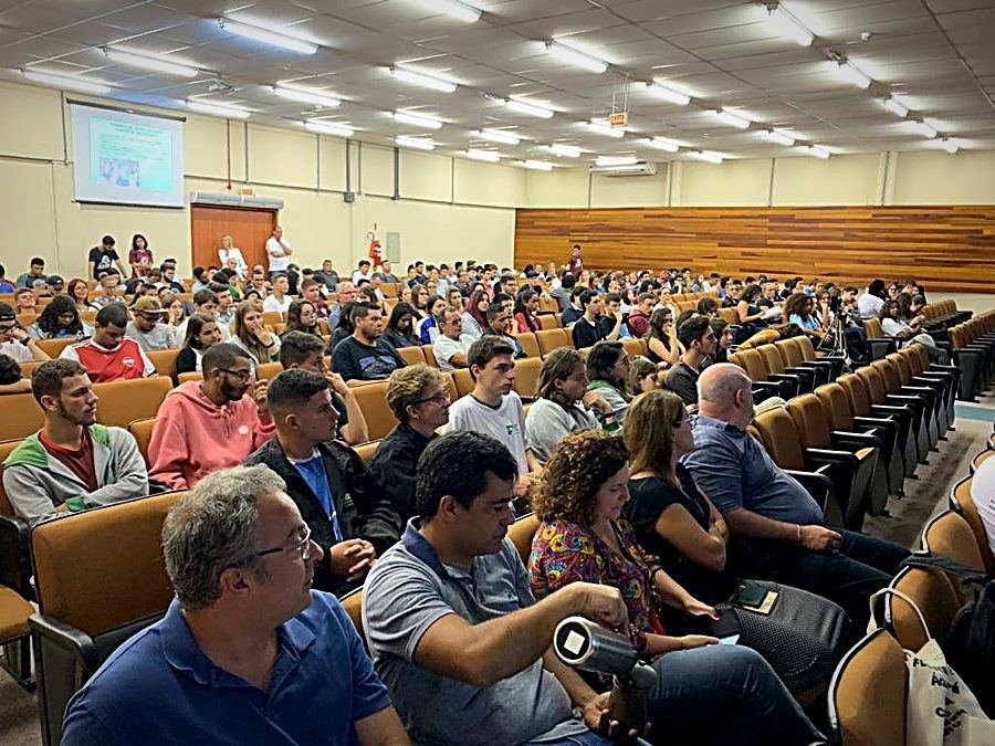 Auditório lotado de estudantes durante a aula magna